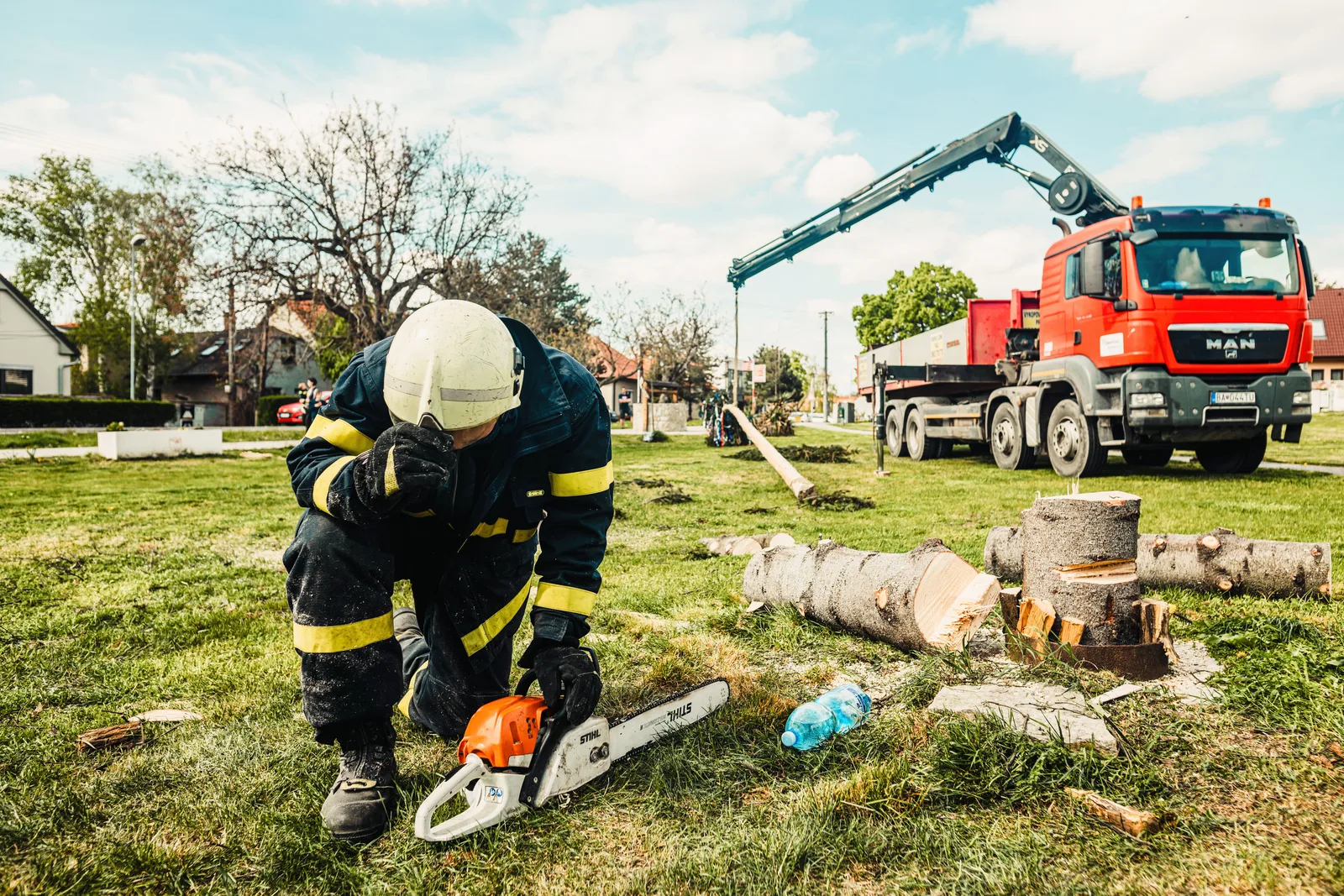 Arborist in safety gear using chainsaw beside truck with crane in an outdoor setting. Tree service marketing and growth for owners in 2027
